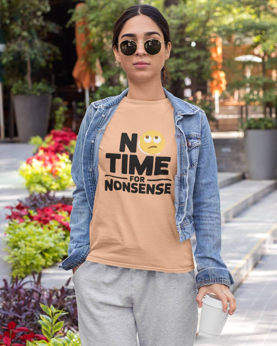 Woman wearing a white RoundNeck t-shirt with 'No Time for Nonsense' text and gray pants outdoors. 