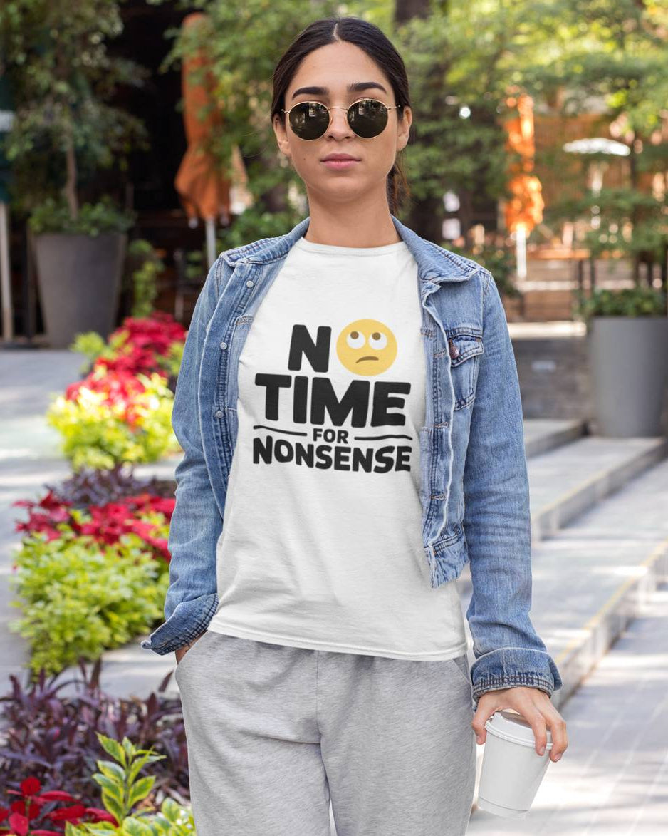 Woman wearing a white RoundNeck t-shirt with 'No Time for Nonsense' text and gray pants outdoors. 