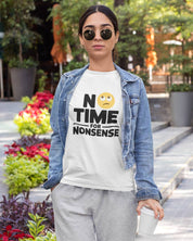 Woman wearing a white RoundNeck t-shirt with 'No Time for Nonsense' text and gray pants outdoors. 